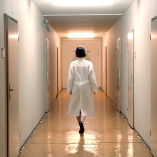 Eine Ärztin nachts allein auf dem Flur eines Krankenhauses. (Symbolbild)