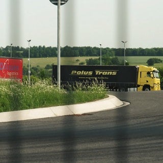 LKW hinterm Zaun auf dem neuen Sicherheitsparkplatz bei Bitburg