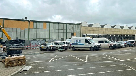Links das durch den Brand zerstörte Außenlager des Theater Ulm. Bei dem Brand wurden große Teile des Kostüm-Fundus, Bühnenbilder und Requisiten zerstört. Probebühnen und Fundus sollen vorübergehend in die benachbarte Sheddachhalle rechts davon ziehen.