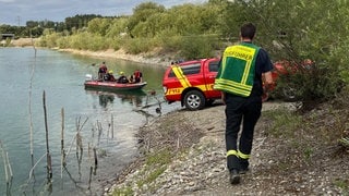 Ein Feuerwehrmann trägt eine Weste mit der Aufschrift "Zugführer" und läuft auf ein Rettungsboot zu, das gerade anlegt. In Mengen übt die Feuerwehr Einsätze der Wasserrettung.
