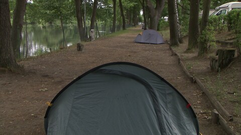Ein Campingplatz mit Zelten und Wohnmobilen neben einem Weiher. Hier wohnt der Bundestagsabgeordnete Johannes Fechner.