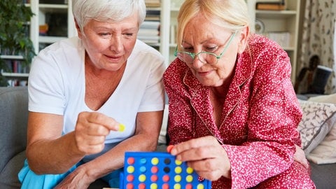 Zwei Senioren spielen konzentriert "Vier gewinnt" in der Freizeit als Gehirnjogging und Denksport.  In SWR1 Leute sprechen wir mit Prof. Frank Jessen über seine Forschung an Früherkennung und Vorbeugung von Alzheimer: Ein aktiver Lebensstil kann bis zu 40 Prozent des Demenz Risikos beeinflussen.