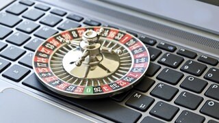 Ein Roulette spiel liegt auf einer Computer-Tastatur