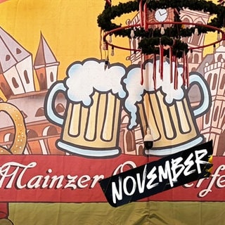 Eine Collage zeigt ein Plakat vom "Mainzer Oktoberfest", überklebt mit dem Wort "November".
