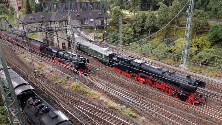 Paralleleinfahrt eines Schnellzuges und eines Kohlezuges in den Bahnhof von Bremburg.