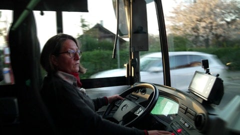 Melanie Schultz arbeitet als Bus- und Straßenbahnfahrerin in Freiburg. Sie sitzt am Steuer eines Busses.