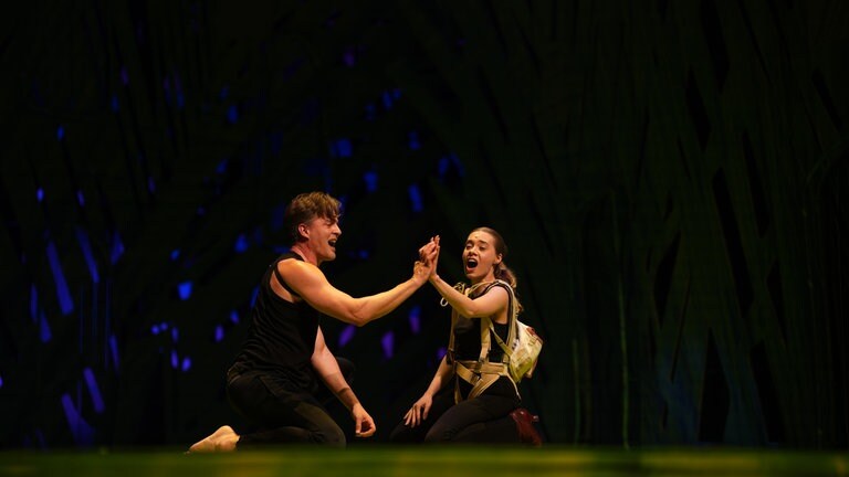 Tarzan und Jane schauen sich an, ihre Hände berühren sich und währenddessen singen sie. (Foto: SWR, Jakob Sax)