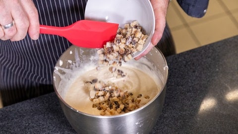 Stollenparfait, das Dessert zum Weihnachtsmenü: Klein geschnittene Stollenwürfel werden der Masse für den Nachtisch hinzugefügt.
