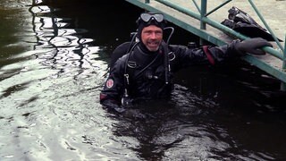 Golfballtaucher Sven ist im Taucheranzug im Wasser