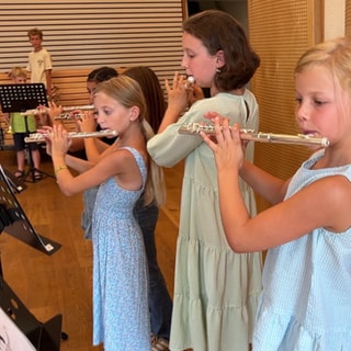 Schülerinnen spielen Querflöte