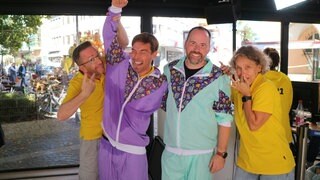 Christian und Claudia (in gelb) lösen Veit und Torsten ab. Endlich ist die Stunde auf dem Laufband rum. Ganze fünf Kilometer haben die beiden Moderatoren gemeinsam geschafft.