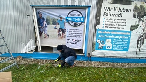 Der Inhaber des Radladens Rülzheim und Helfer sichern das zerstörte Schaufenster.