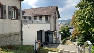 Außenansicht der JVA Tübingen mit vergittertem und mit Stacheldraht gesichertem Hof zwischen mehreren Gebäuden.