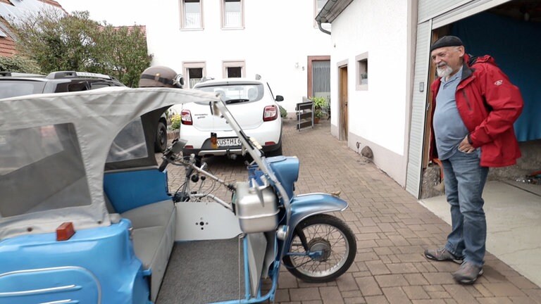 Hierzuland Gumbsweiler Mann vor skurrilem Gefährt