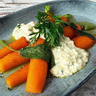 Glasierte Honig-Karotten mit Walnuss-Pesto auf einem blauen Teller angerichtet