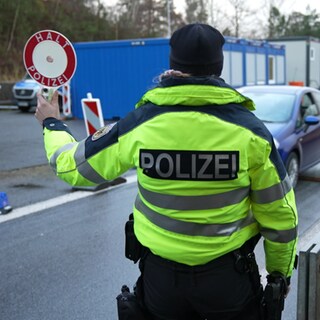 Ein Bundespolizist hält ein Auto an einem Grenzübergang an. Der Bundestag hat sich am Mittwoch für dauerhafte Grenzkontrollen ausgesprochen.