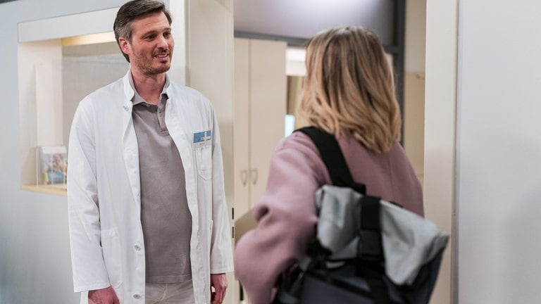 Dr. Schröder spricht auf dem Krankenhausflur mit Celine