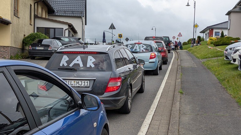 Autoschlange in Nürburg wartet darauf auf die Campingplätze gelassen zu werden.