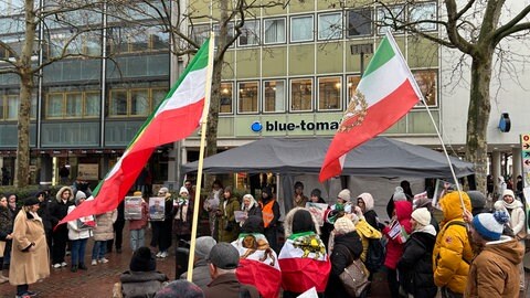 Menschen mit persischen Schah-Fahnen. Sie fordern Freiheit für Iran und solidarisieren sich mit den Protesten in ihrer Heimat. 