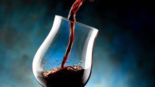 Rotwein wird in ein Glas gegossen