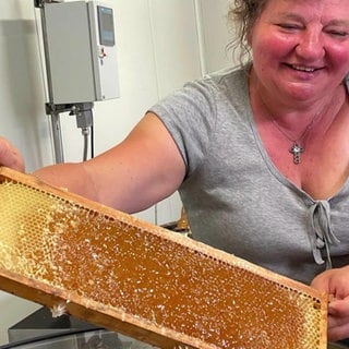 Imkerin Helena Strobel mit einer großen Honigwabe