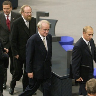 Nach seiner Rede im Deutschen Bundestag 2001 geht der russische Präsident Wladimir Putin (rechts) durch den Plenarsaal im Reichstagsgebäude, gefolgt von Bundespräsident Johannes Rau, Bundestagspräsident Wolfgang Thierse und Bundeskanzler Gerhard Schröder