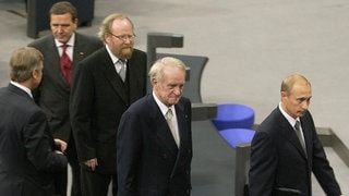 Nach seiner Rede im Deutschen Bundestag 2001 geht der russische Präsident Wladimir Putin (rechts) durch den Plenarsaal im Reichstagsgebäude, gefolgt von Bundespräsident Johannes Rau, Bundestagspräsident Wolfgang Thierse und Bundeskanzler Gerhard Schröder