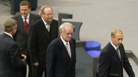 Nach seiner Rede im Deutschen Bundestag 2001 geht der russische Präsident Wladimir Putin (rechts) durch den Plenarsaal im Reichstagsgebäude, gefolgt von Bundespräsident Johannes Rau, Bundestagspräsident Wolfgang Thierse und Bundeskanzler Gerhard Schröder