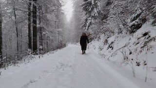 Eine Frau läuft durch den Schnee im Wald