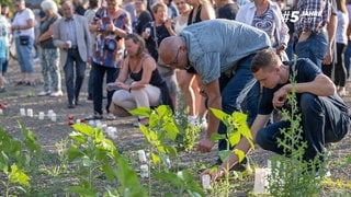 Das Archivfoto aus dem Jahr 2022 zeigt Menschen, die in Erinnerung an die Toten der Ahrflut Kerzen aufstellen und anzünden.