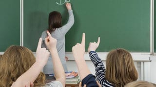 Kinder melden sich im Unterricht.