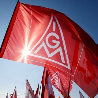 Teilnehmer halten bei einem bundesweiten Aktionstag Flaggen mit dem Logo der IG Metall hoch. Ab Oktober 26 verhandelt die IG Metall nach eigenen Angaben wieder über höhere Entgelte für bundesweit 3,8 Millionen Beschäftigte der Metall- und Elektroindustrie.