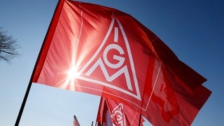Teilnehmer halten bei einem bundesweiten Aktionstag Flaggen mit dem Logo der IG Metall hoch. Ab Oktober 26 verhandelt die IG Metall nach eigenen Angaben wieder über höhere Entgelte für bundesweit 3,8 Millionen Beschäftigte der Metall- und Elektroindustrie.