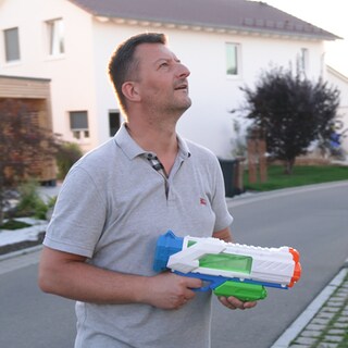 Michael Rani mit Wasserpistole in der Hand wegen Taubenproblem in Balinger Neubaugebiet. Tauben nisten unter Solaranlagen und verdrecken Gärten und Balkone.
