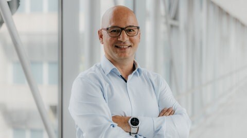 Prof. Dr. Emrah Düzel lacht in die Kamera.