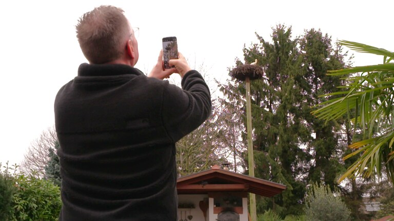 Uwe Bamberger fotografiert den Storch in seinem Garten