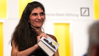 Die Gewinnerin des Deutschen Buchpreises 2026, Shida Bazyar, steht auf der Bühne.