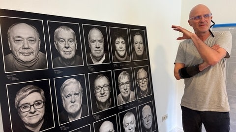 Ex-Stasi-Häftling André Wagenzik neben den Portraits von anderen Insassen für die Ausstellung im DDR-Museum in Pforzheim.