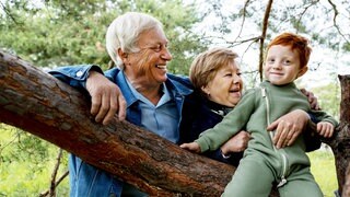 Großeltern und Enkel im Wald: Wenn Kinder und Zeit mit Oma und Opa verbringen, macht das nicht nur einfach Spaß, sondern alle profitieren – auch die Eltern.