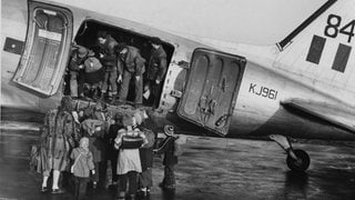 Kinder stehen am 5. November 1948 vor der britischen "Douglas Dakota" KJ 961 auf dem Rollfeld des Berliner Flughafens Tegel. Sie werden wegen des bevorstehenden Winters zu Verwandten in die westlichen Teile Deutschlands geflogen.