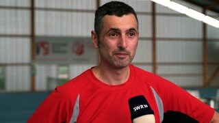 Ralf Illing hatte mit 42 Jahren einen Schlaganfall. Er steht in Sportkleidung in einer Tennishalle.