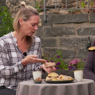 Zaneta Frankenfeld und Susanne Nett sitzen an einem Tisch draußen und schauen sich die Cantuccini mit Bucheckern an.