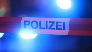 Blaulichter leuchten hinter einem Absperrband der Polizei. In Filderstadt-Bonlanden hat ein Bauhof-Mitarbeiter die Leiche eines Menschen gefunden.