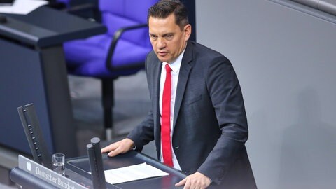 Man sieht den Bundestagsabgeordneten Johannes Fechner im Anzug am Rednerpult im Bundestag.