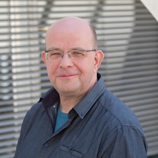 Stefan Eich steht im Gang eines SWR-Gebäudes.