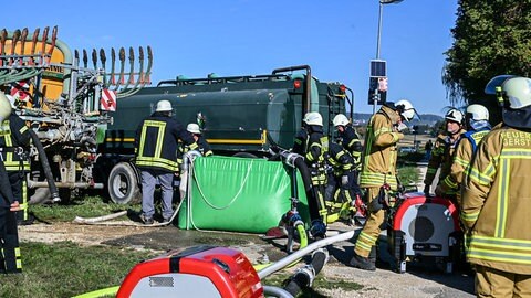 Landwirte aus der Umgebung bringen mit Traktoren Güllefässer mit Wasser zum Brand des landwirtschaftlichen Gebäudes in Altheim (Alb). 