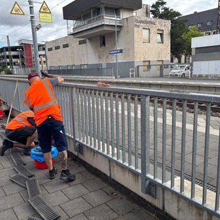 Die Deutsche Bahn setzt jetzt mobile Handwerkerteams ein, um Bahnhöfe in der Pfalz aufzuwerten. Hier sind zwei solche Handwerker am Bahnhof Frankenthal zu sehen.
