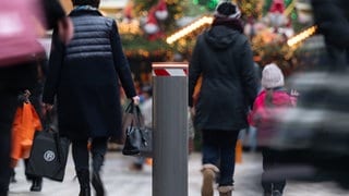Eine festverbaute Polleranlage steht an einer Straße am Rand des Stuttgarter Marktplatzes, auf dem ein Weihnachtsmarkt stattfindet.