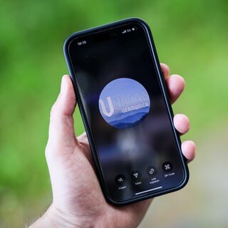 Ein Mann hält ein Smartphone in der Hand, auf der die Instragram-Seite und das Logo von "Unitas Germanica" zu sehen ist.