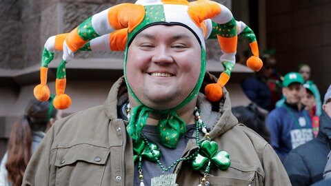 Ein Mann trägt bei der Saint Patrick's Day Parade in New York einen lustigen Hut in den irischen Farben grün, weiß und orange. Orange steht dabei für die protestantische Bewegung, wohingegen das Grün die Katholiken repräsentieren soll.